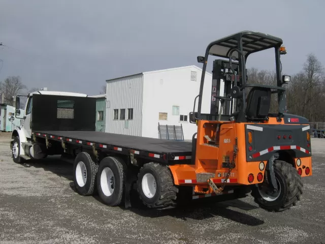 Kenworth-Peterbilt flatbed truck with forklift kit and Moffett forklift hanging on back. Moffett forklift is not included in truck prices, and is sold seperately.